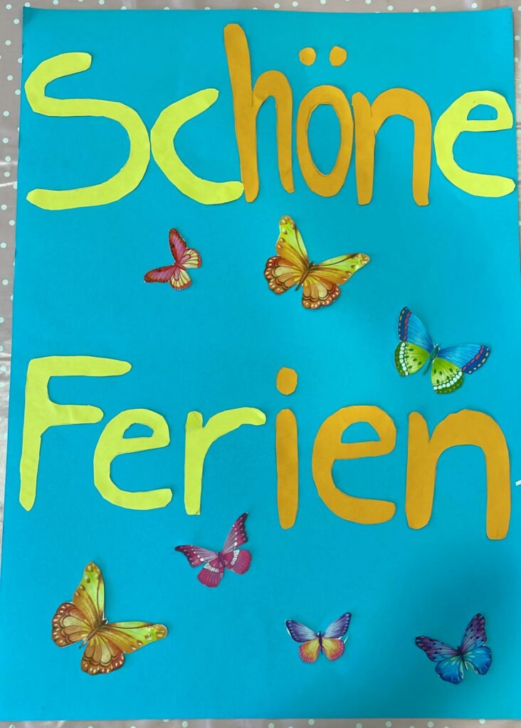 Gebasteltes Plakat mit Schmetterlingen und der Aufschrift "Schöne Ferien"